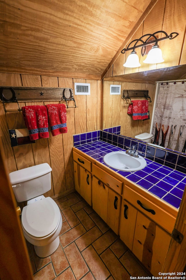 bathroom featuring vanity, wood ceiling, wooden walls, tile patterned floors, and toilet