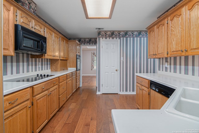 kitchen featuring light hardwood / wood-style flooring and black appliances