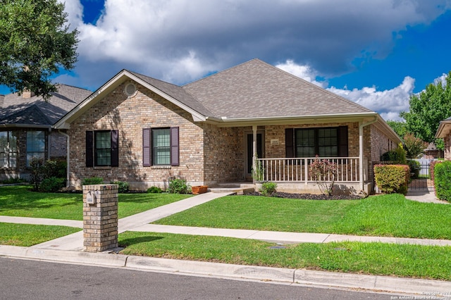 ranch-style home with a front yard and covered porch