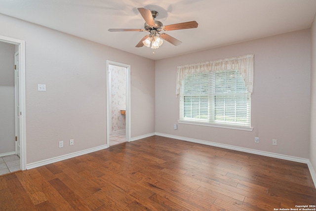 empty room with ceiling fan and hardwood / wood-style flooring