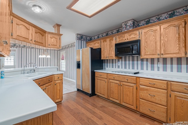 kitchen with refrigerator with ice dispenser, white stovetop, sink, and light hardwood / wood-style flooring