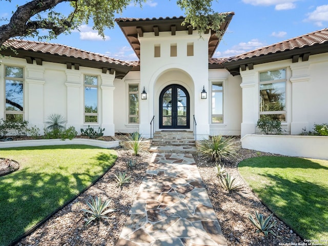 property entrance featuring french doors and a yard