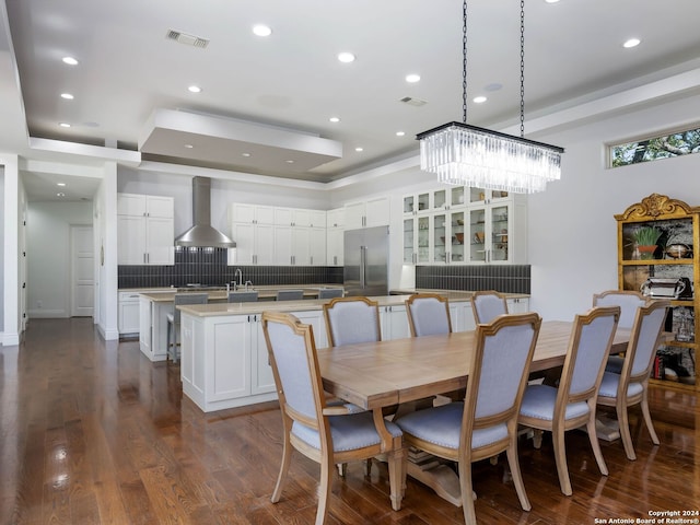 dining room featuring dark hardwood / wood-style floors, sink, and an inviting chandelier