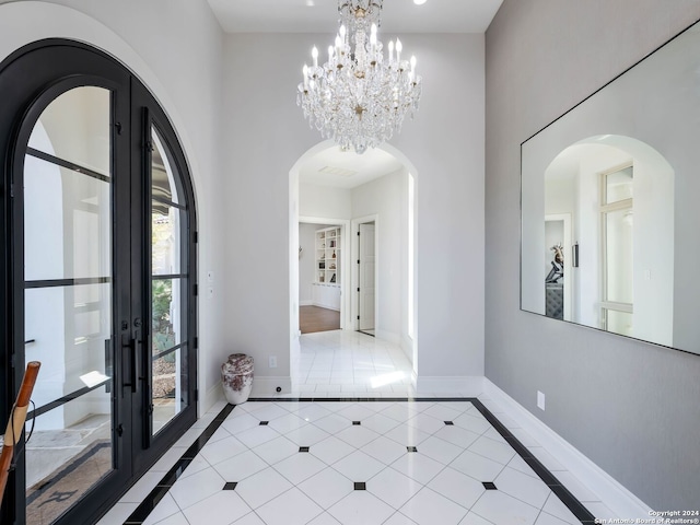 tiled foyer entrance featuring an inviting chandelier