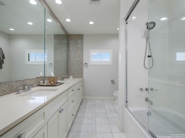 full bathroom featuring shower / bath combination with glass door, plenty of natural light, toilet, and vanity