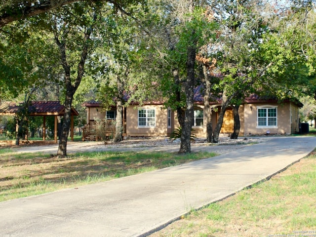 view of property hidden behind natural elements with cooling unit