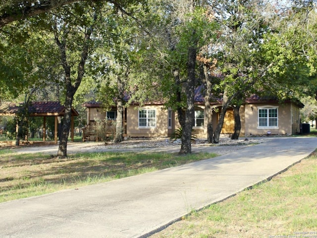 obstructed view of property with concrete driveway and stucco siding
