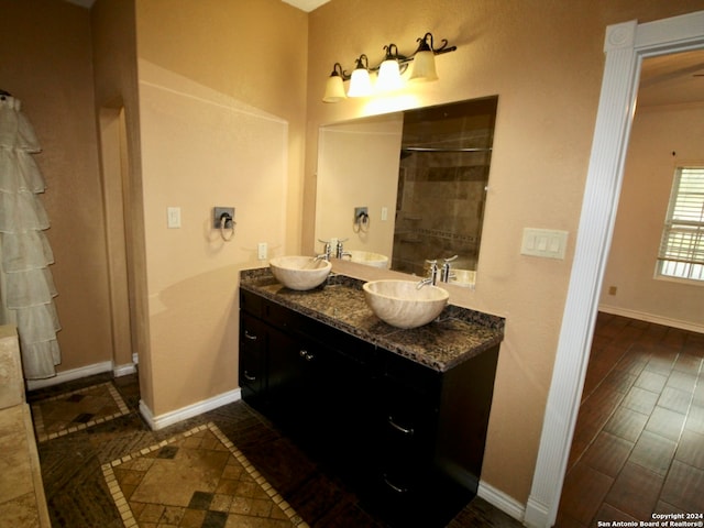 bathroom with tiled shower, vanity, and hardwood / wood-style floors