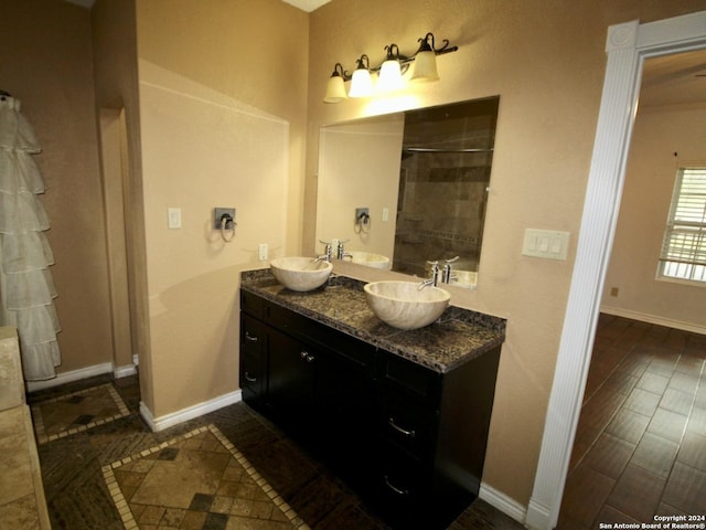 full bathroom featuring baseboards, a sink, and a tile shower