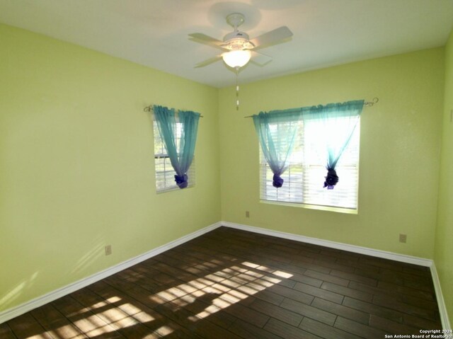 empty room with dark hardwood / wood-style flooring and ceiling fan