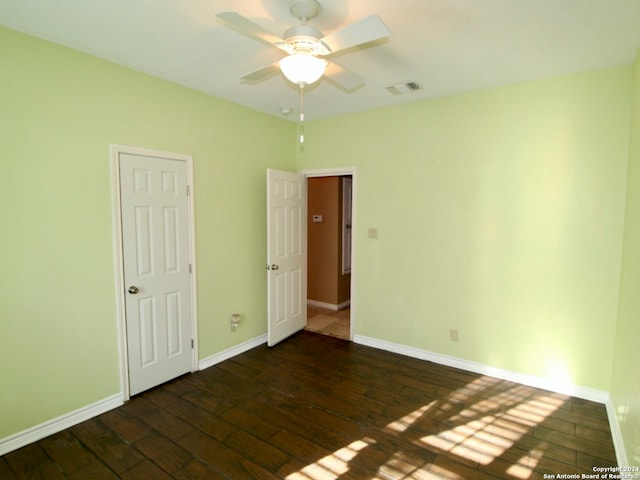 unfurnished room with dark hardwood / wood-style flooring and ceiling fan