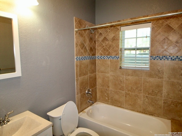 full bathroom featuring vanity, tiled shower / bath combo, and toilet