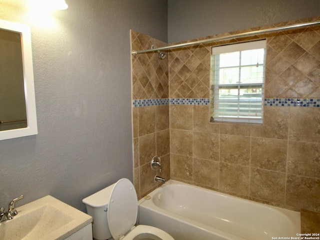 full bathroom featuring a textured wall, toilet, vanity, and shower / bathtub combination