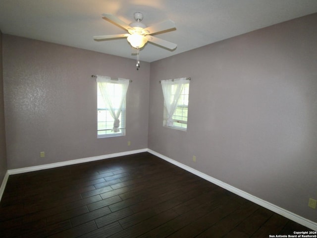 unfurnished room with a ceiling fan, dark wood-style flooring, and baseboards