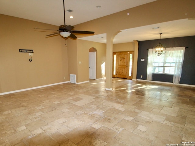 unfurnished living room with ceiling fan with notable chandelier