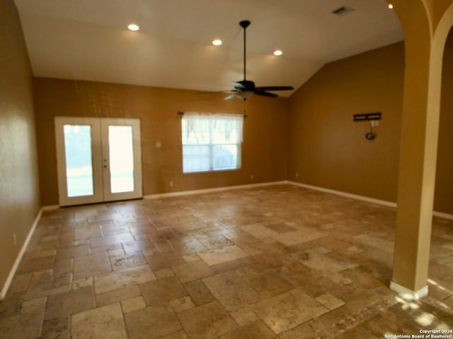 empty room featuring ceiling fan, french doors, and vaulted ceiling