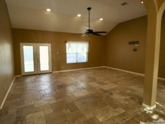 unfurnished room featuring stone tile floors, french doors, baseboards, arched walkways, and ceiling fan