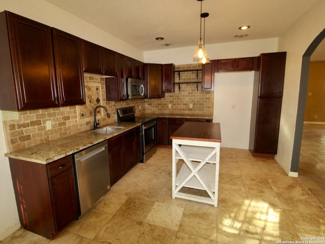 kitchen with decorative backsplash, visible vents, appliances with stainless steel finishes, arched walkways, and a sink