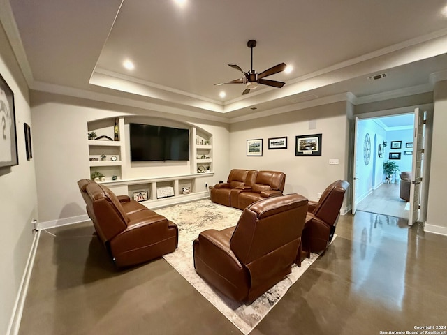 living room with ceiling fan, a raised ceiling, ornamental molding, and built in shelves