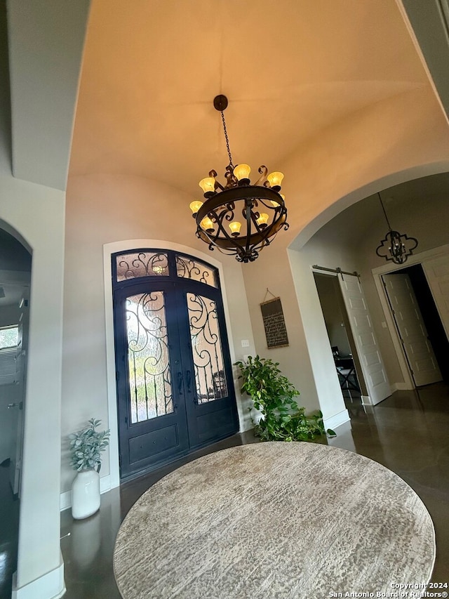 foyer entrance featuring an inviting chandelier and vaulted ceiling