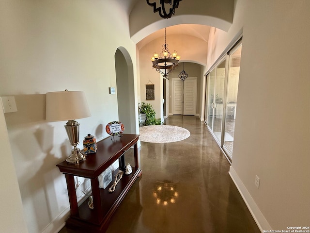 hallway with vaulted ceiling and a chandelier