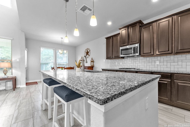 kitchen featuring a wealth of natural light, an island with sink, and appliances with stainless steel finishes