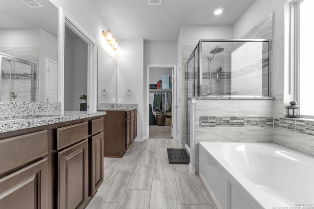 bathroom with vanity and separate shower and tub