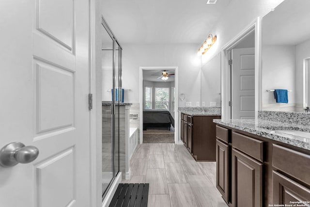 bathroom featuring ceiling fan, a shower with shower door, and vanity