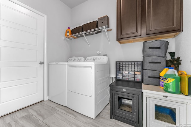 clothes washing area with cabinets and washer and clothes dryer