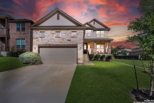 view of front of house featuring a yard, covered porch, and a garage