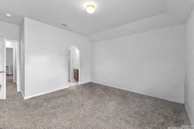 spare room with lofted ceiling and light carpet