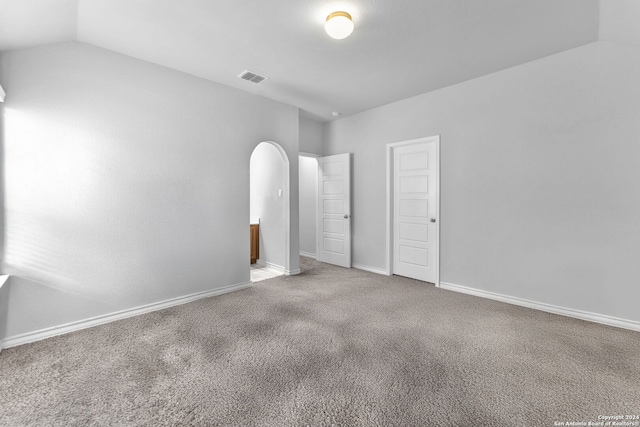 unfurnished bedroom featuring carpet and vaulted ceiling