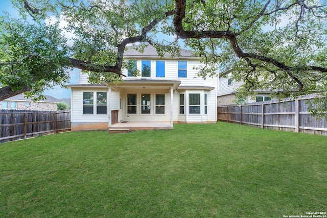 rear view of property featuring a yard