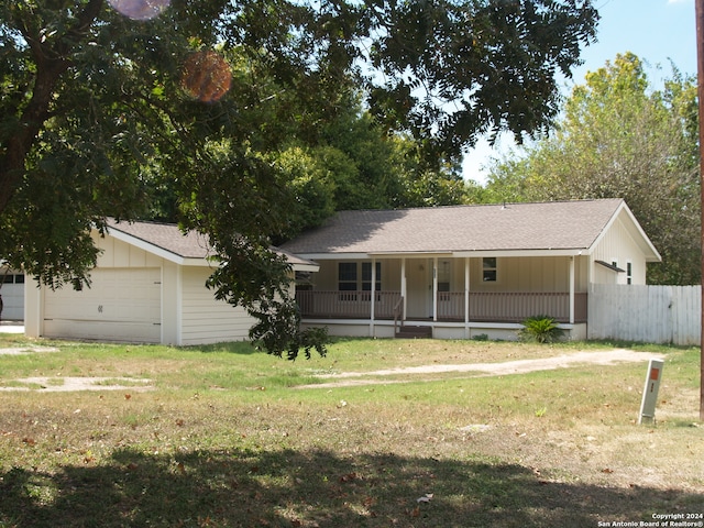 single story home with a front lawn, a porch, and a garage