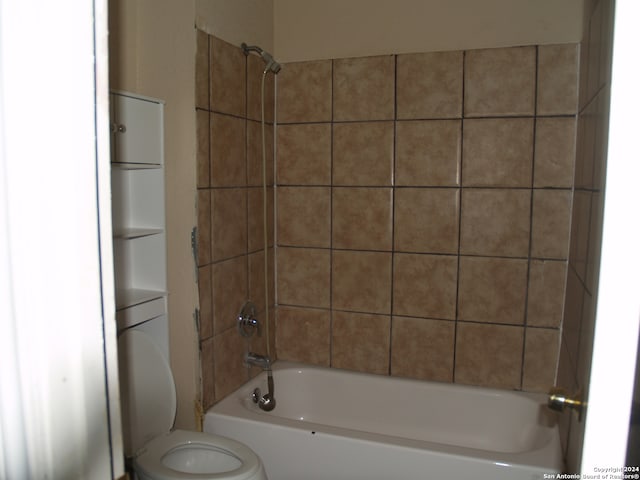 bathroom featuring tiled shower / bath and toilet