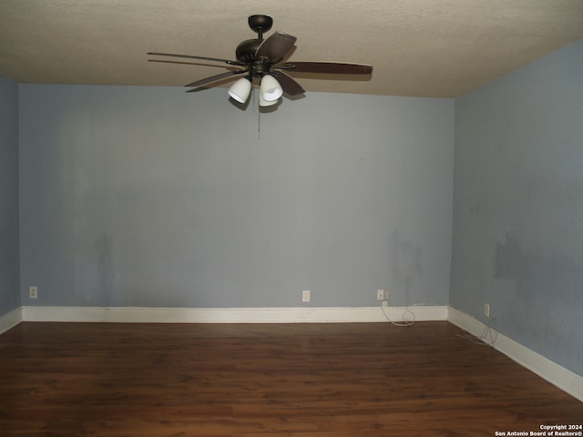 empty room featuring a textured ceiling, dark hardwood / wood-style floors, and ceiling fan