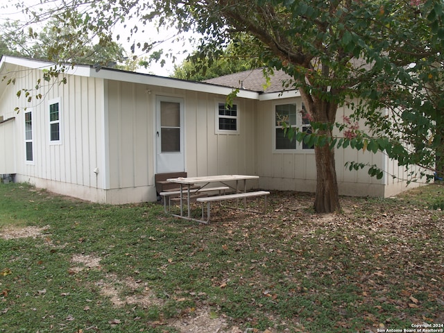 rear view of property with a yard