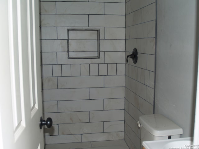 bathroom with toilet and tiled shower