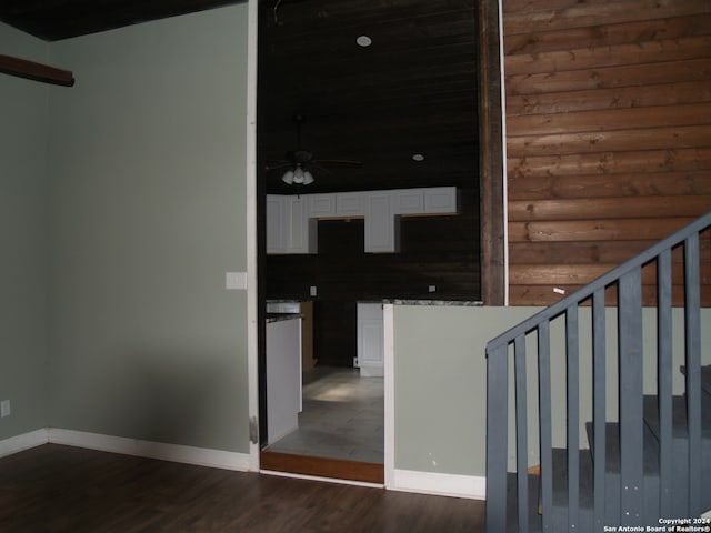 stairs featuring ceiling fan, rustic walls, and hardwood / wood-style floors