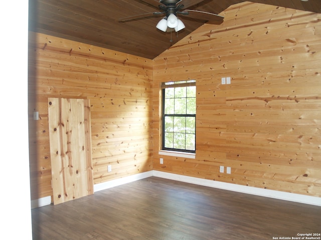 spare room featuring wood walls, ceiling fan, and vaulted ceiling