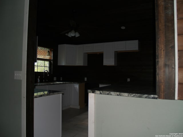 kitchen with backsplash, white cabinetry, ceiling fan, and sink