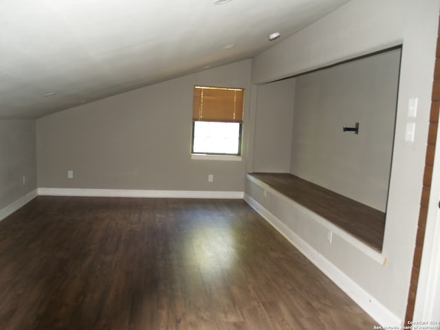 additional living space featuring vaulted ceiling and dark hardwood / wood-style floors