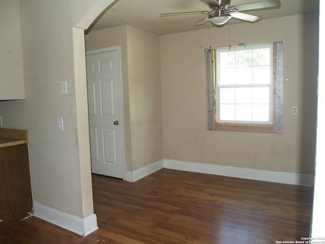 empty room with ceiling fan and dark hardwood / wood-style flooring