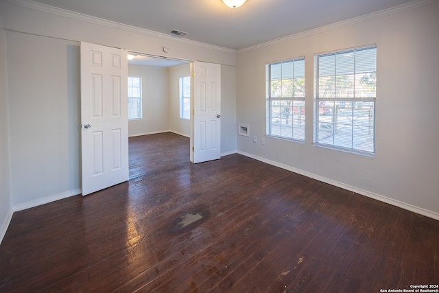 empty room featuring ornamental molding and dark wood-type flooring