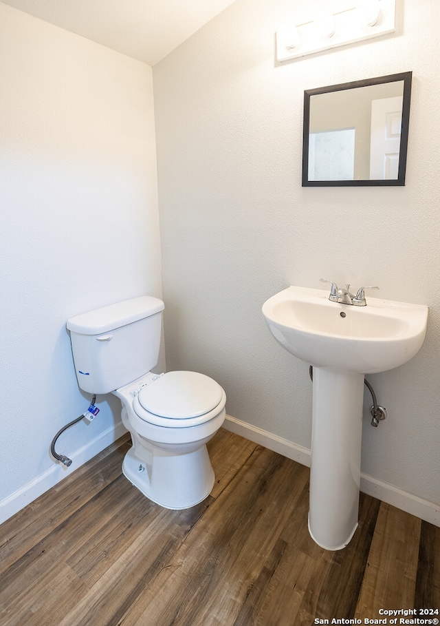 bathroom featuring hardwood / wood-style flooring and toilet