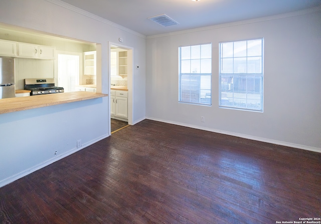 unfurnished living room featuring crown molding and dark hardwood / wood-style flooring