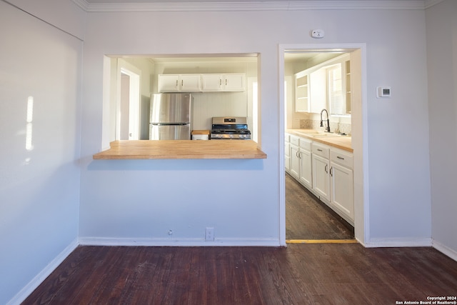 kitchen with appliances with stainless steel finishes, dark hardwood / wood-style floors, sink, and white cabinetry