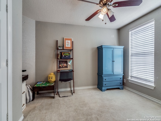 misc room with ceiling fan, a textured ceiling, and light carpet