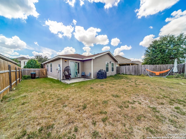 rear view of property with a lawn and a patio