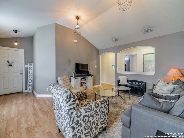 living room featuring vaulted ceiling and light hardwood / wood-style floors